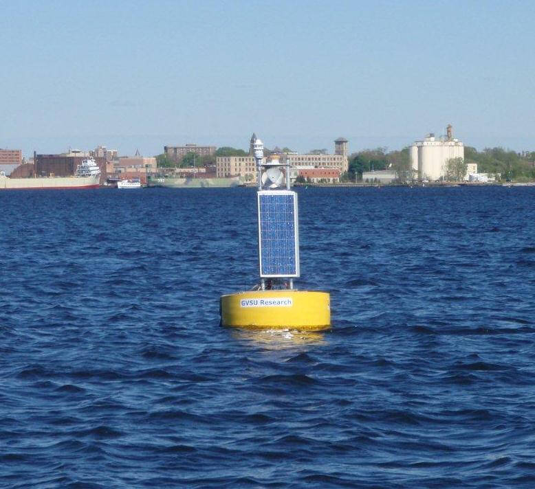 The Muskegon Lake Observatory buoy seen from the lake with AWRI and downtown Muskegon visible on the horizon.